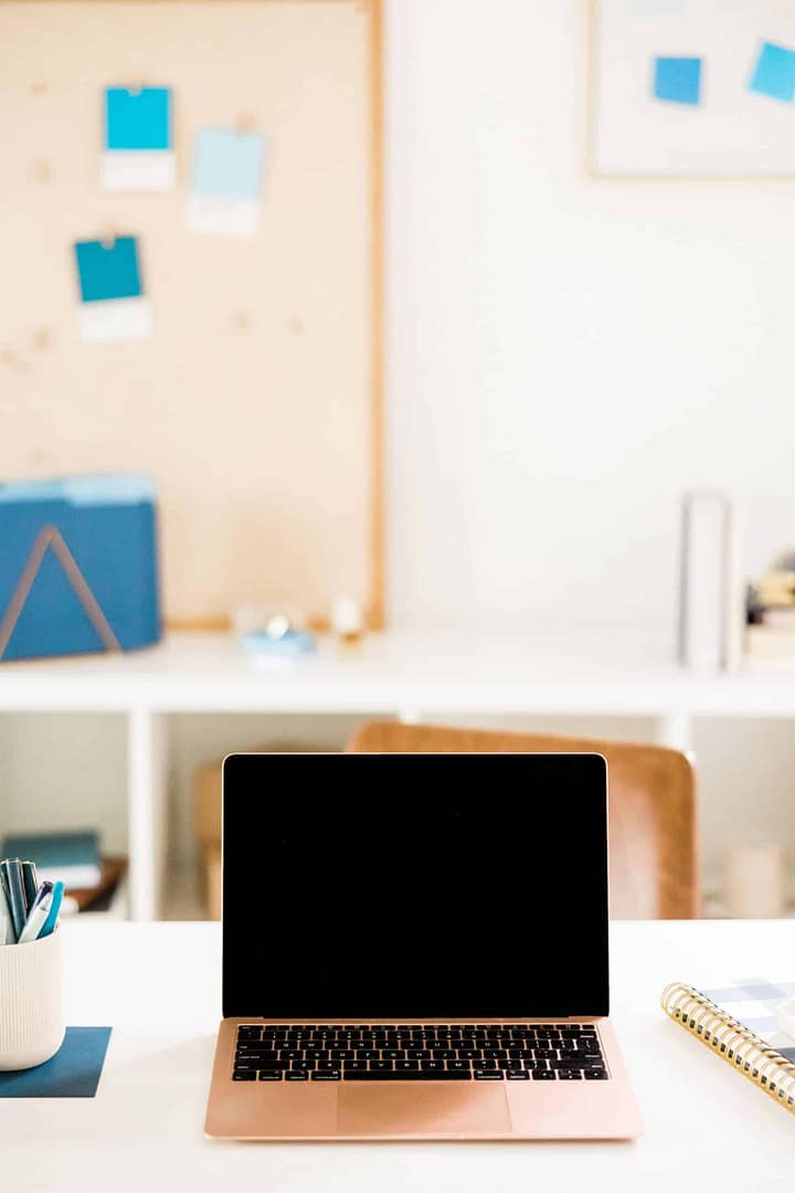 A laptop sits on a desk in a home office. A laptop sits on a desk in a home office.